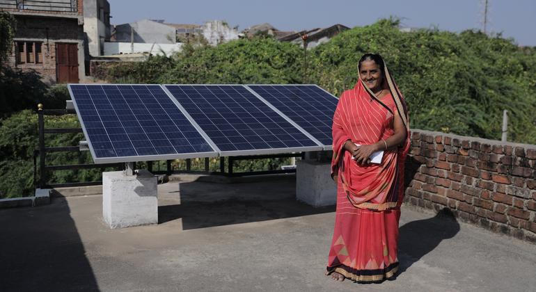 Woman standing beside rooftop solar panels
